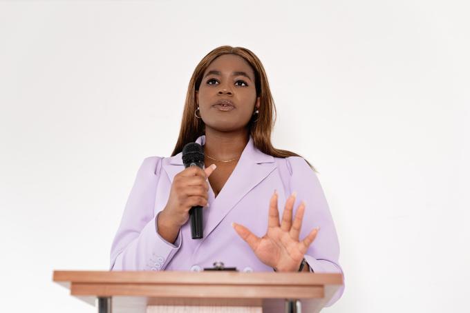 Woman in a Blazer Holding a Microphone