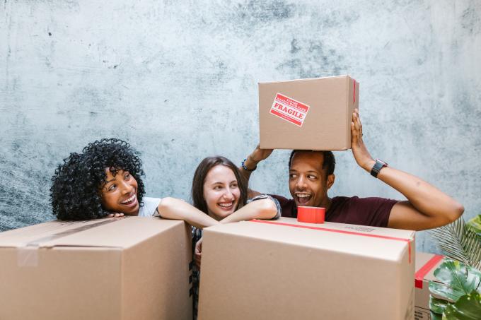 2 Women and Man Surrounded by Cardboard Boxes